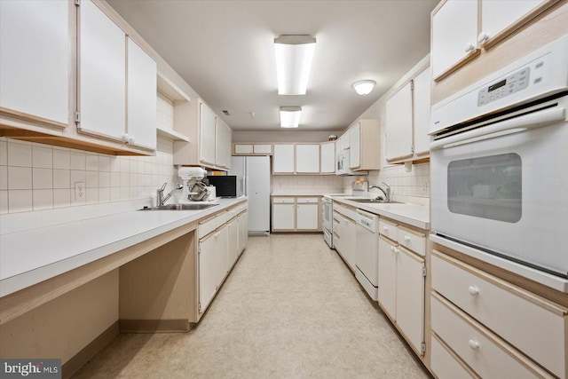 kitchen featuring tasteful backsplash, white appliances, white cabinetry, and sink