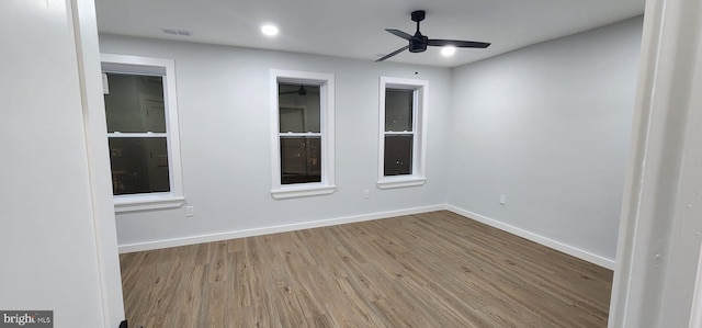 empty room with ceiling fan and light hardwood / wood-style flooring