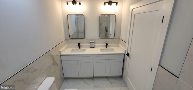 bathroom featuring vanity and tile walls