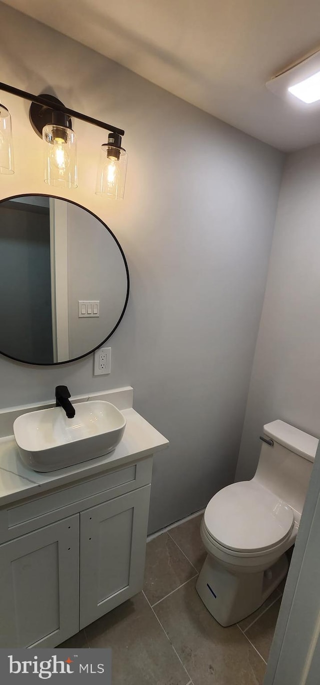 bathroom with tile patterned flooring, vanity, and toilet