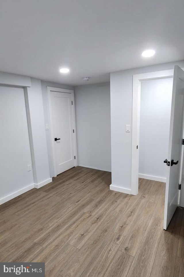 basement with light hardwood / wood-style flooring