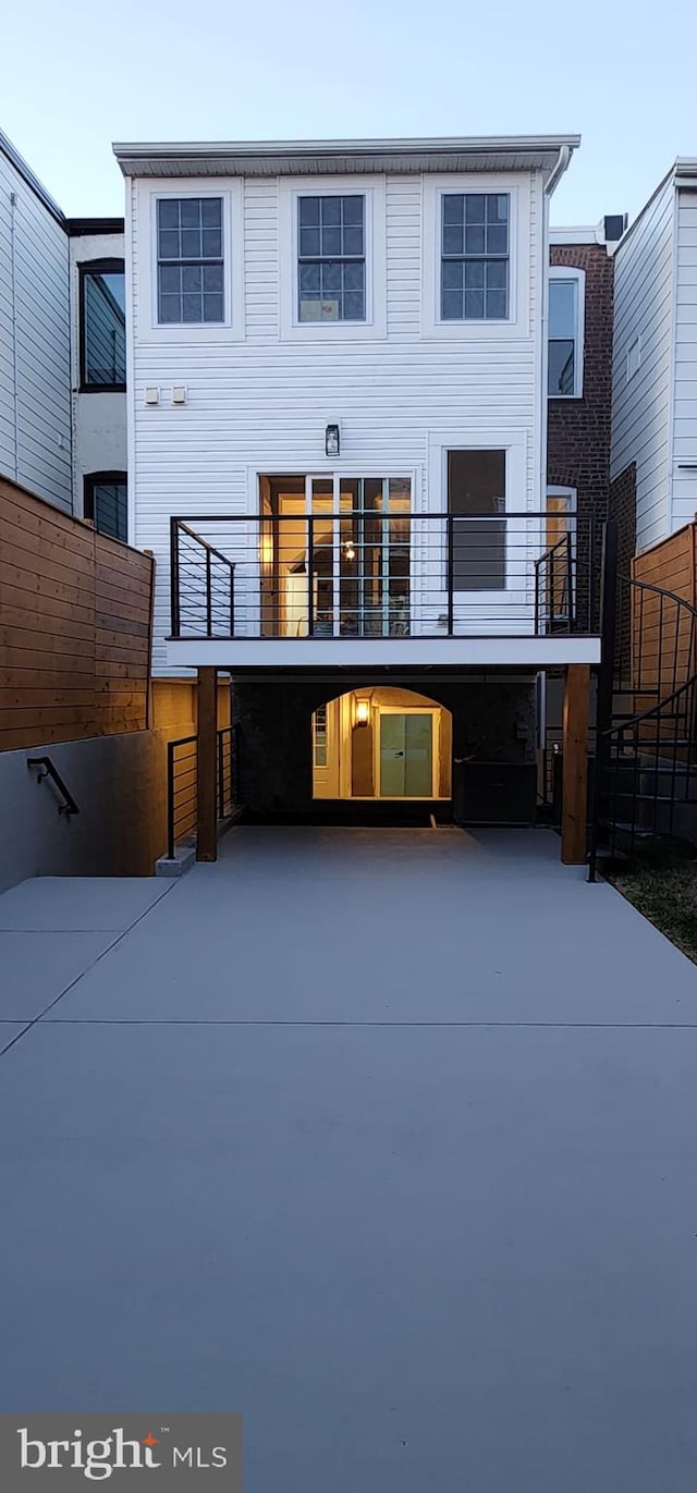 rear view of house with a carport and a balcony