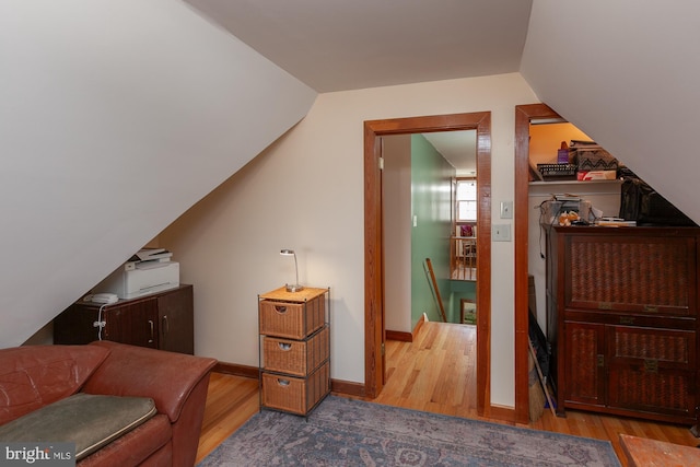 interior space with hardwood / wood-style flooring and vaulted ceiling