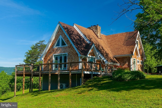 back of property with a wooden deck and a lawn