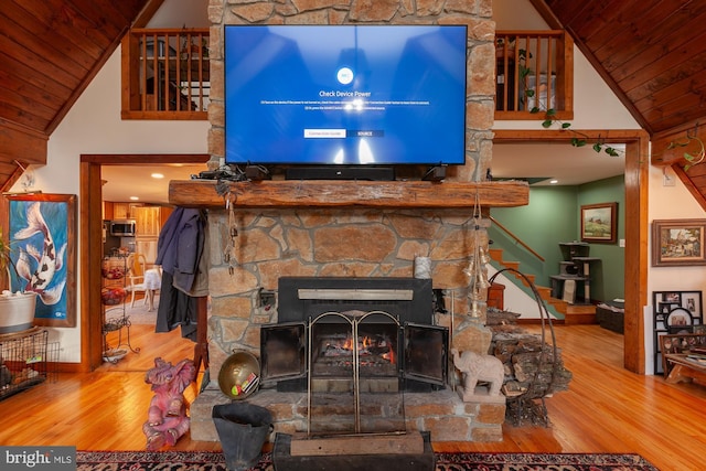 interior details with wood-type flooring, a stone fireplace, and wood ceiling