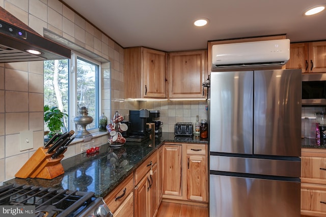 kitchen featuring a wall mounted air conditioner, tasteful backsplash, dark stone counters, appliances with stainless steel finishes, and light wood-type flooring