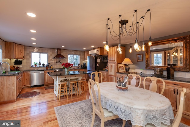 dining room featuring light wood-type flooring, a wealth of natural light, and sink