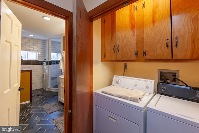 laundry room with separate washer and dryer and cabinets