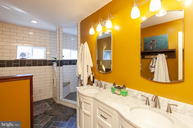 bathroom with tile patterned floors, vanity, tile walls, and tiled shower