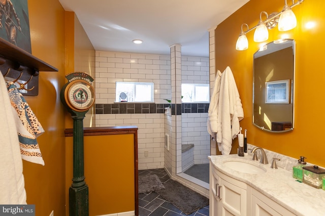 bathroom with tiled shower, vanity, and tile patterned floors