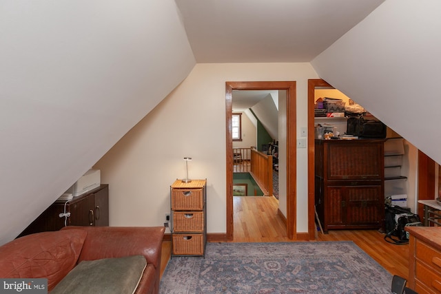 additional living space featuring light hardwood / wood-style floors and vaulted ceiling