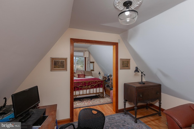 bedroom with lofted ceiling and wood-type flooring