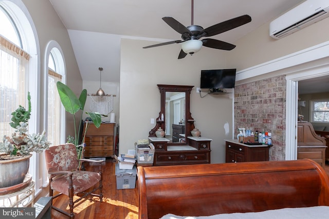 interior space with lofted ceiling, hardwood / wood-style flooring, a wall mounted AC, and a healthy amount of sunlight