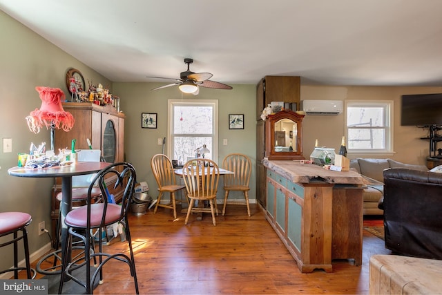 kitchen featuring an AC wall unit, a wealth of natural light, dark hardwood / wood-style flooring, and ceiling fan