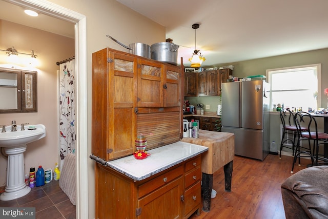 kitchen with stainless steel fridge, pendant lighting, and dark wood-type flooring