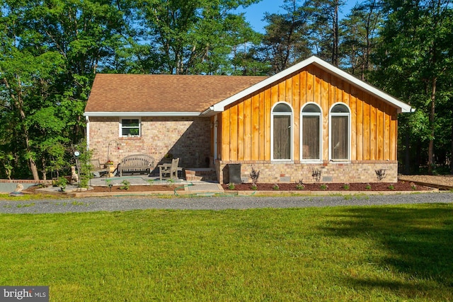 back of house with a yard and a patio