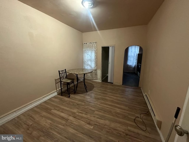 interior space featuring baseboard heating and dark hardwood / wood-style floors