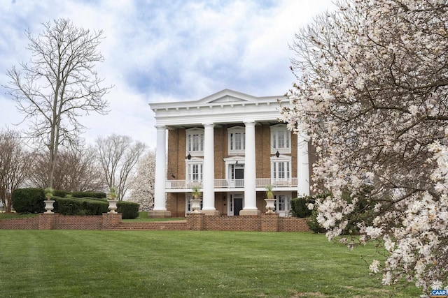 greek revival house with a balcony and a front lawn