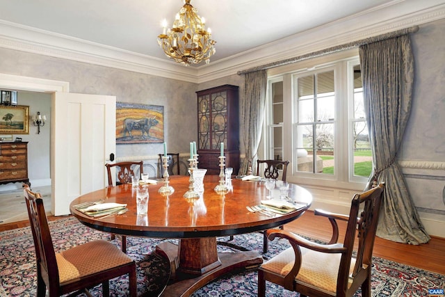 dining room with hardwood / wood-style floors, ornamental molding, and an inviting chandelier