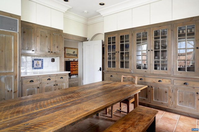 kitchen featuring decorative backsplash, light tile patterned floors, and ornamental molding