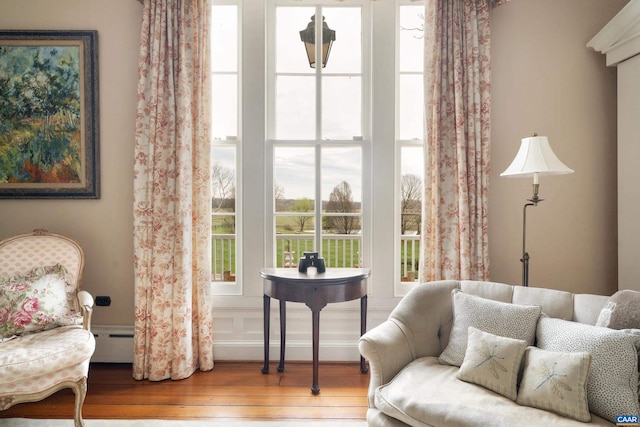 sitting room featuring hardwood / wood-style flooring and a baseboard heating unit