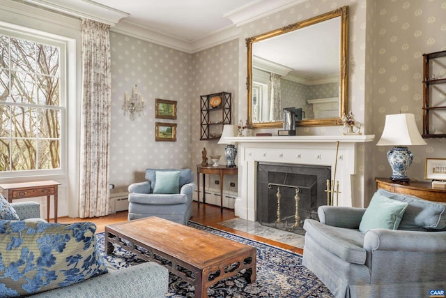 living area with hardwood / wood-style flooring, a baseboard radiator, and crown molding