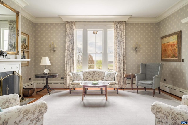 sitting room with hardwood / wood-style floors, ornamental molding, plenty of natural light, and a baseboard heating unit