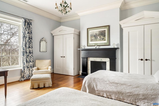 bedroom with hardwood / wood-style flooring, a notable chandelier, and crown molding