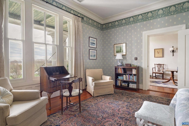 living area with hardwood / wood-style flooring, plenty of natural light, and ornamental molding