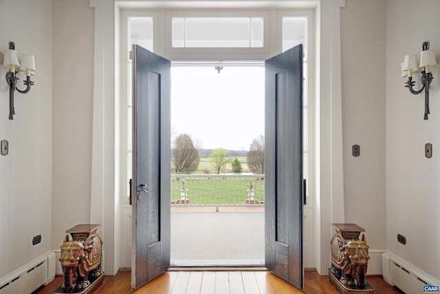 doorway with baseboard heating and light hardwood / wood-style floors