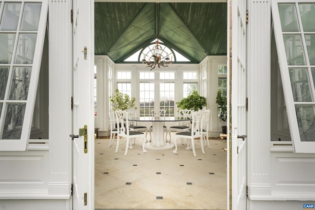 sunroom / solarium with a chandelier and vaulted ceiling