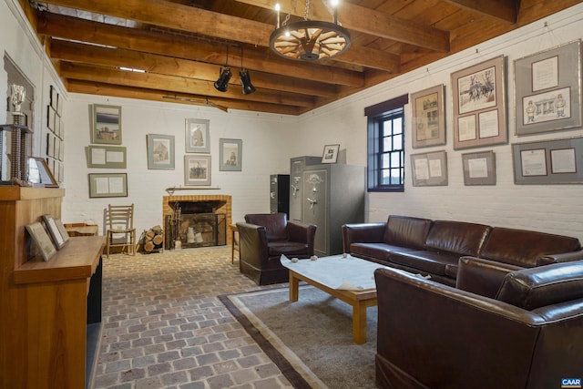 living room featuring beam ceiling, wooden ceiling, brick wall, and a brick fireplace