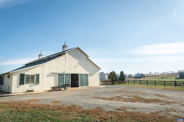 back of house with a rural view