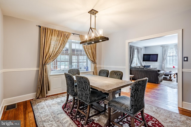 dining area featuring an inviting chandelier, hardwood / wood-style floors, and a healthy amount of sunlight