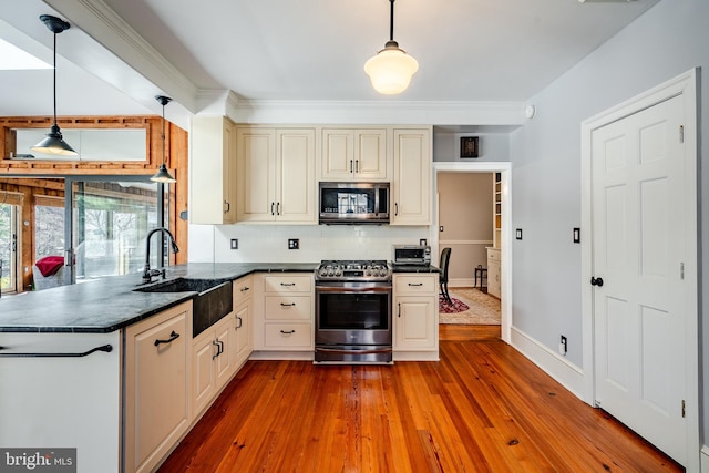 kitchen featuring pendant lighting, hardwood / wood-style floors, and appliances with stainless steel finishes