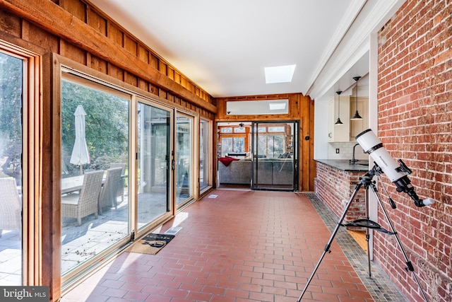 unfurnished sunroom with a skylight