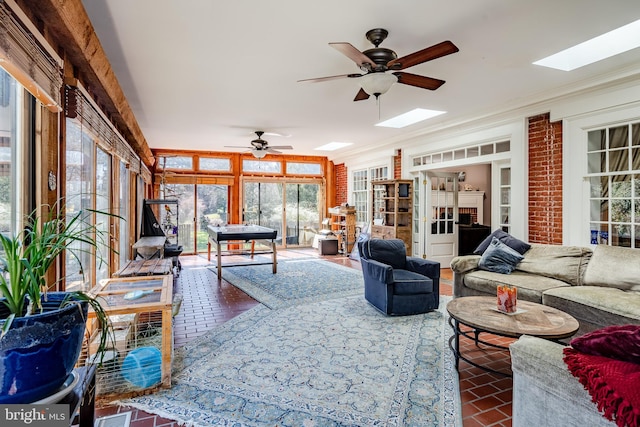 sunroom / solarium with ceiling fan and a skylight