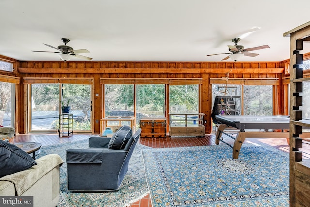 living room with wood walls and ceiling fan