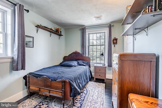 bedroom with dark wood-type flooring and a textured ceiling