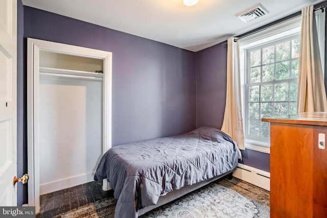 bedroom featuring a closet and a baseboard heating unit