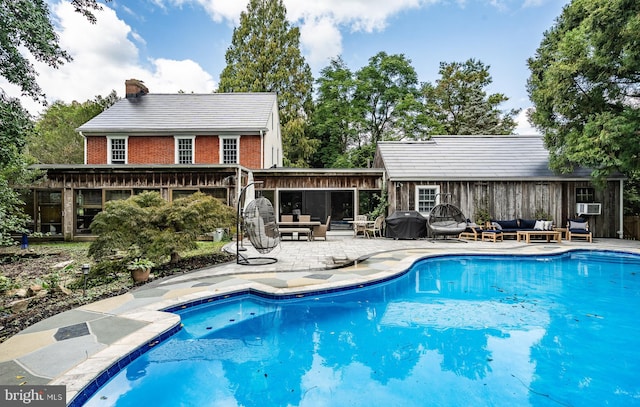 view of swimming pool featuring outdoor lounge area, a patio area, and a grill