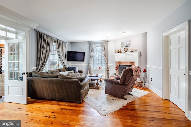 living room featuring light hardwood / wood-style floors and a brick fireplace