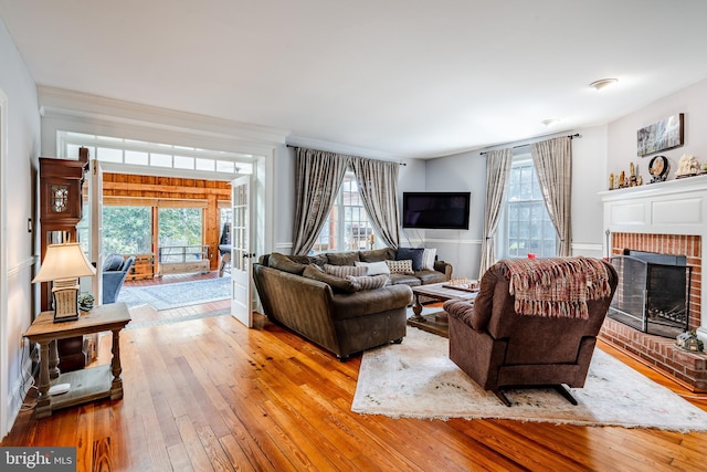 living room featuring a brick fireplace and light hardwood / wood-style floors