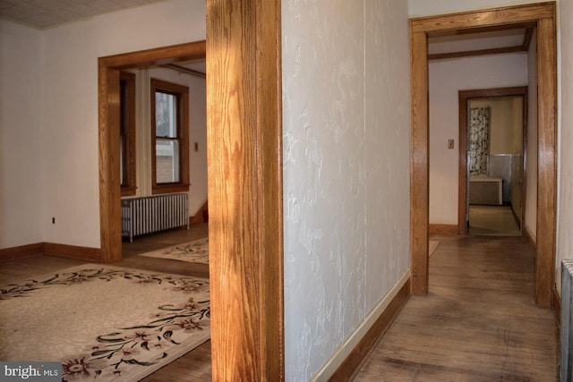 hallway with dark wood-type flooring and radiator