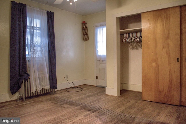 unfurnished bedroom featuring ceiling fan, a closet, and dark wood-type flooring