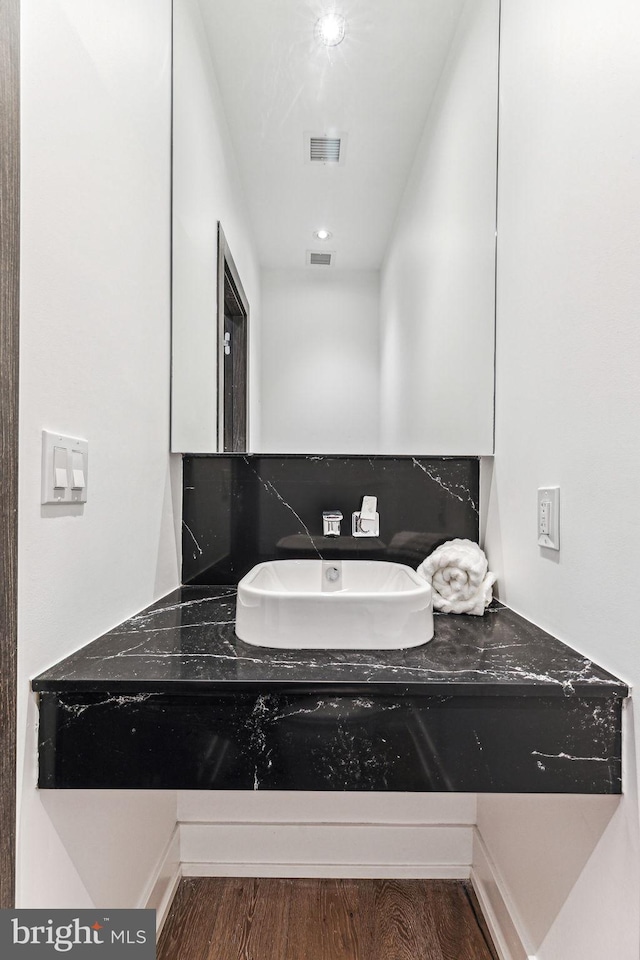 bathroom featuring hardwood / wood-style flooring, vanity, and tasteful backsplash