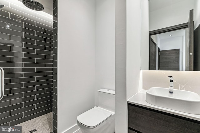 bathroom featuring vanity, toilet, and tiled shower