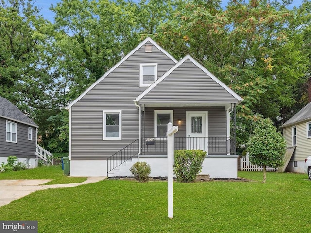 bungalow-style house featuring covered porch and a front yard