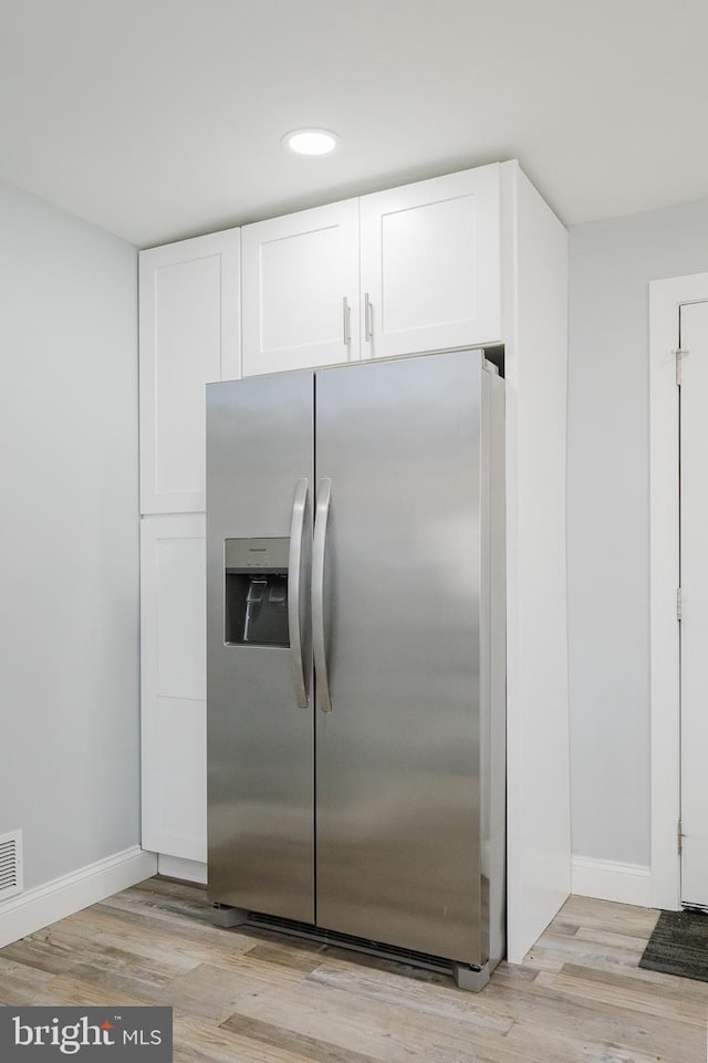 kitchen with white cabinets, light wood-type flooring, and stainless steel fridge with ice dispenser