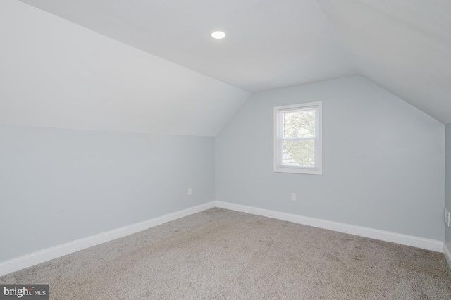 bonus room featuring vaulted ceiling and carpet flooring